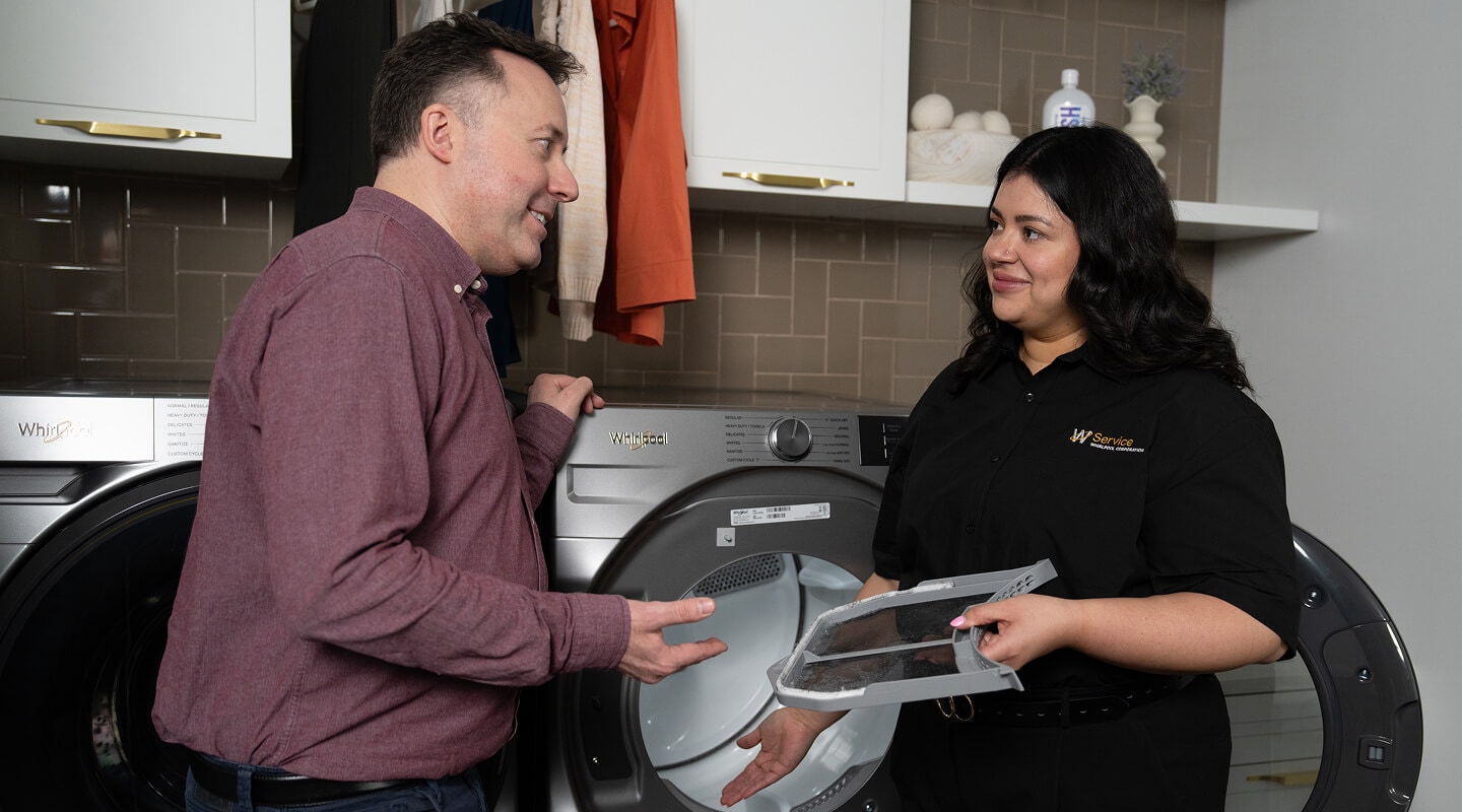 A technician helping a man with his dryer A technician helping a man with his dryer