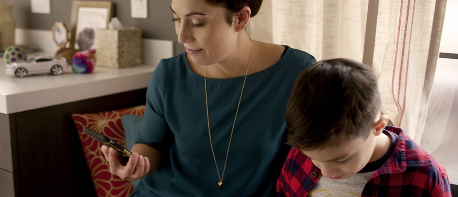 Woman looking at her phone sitting next to her son