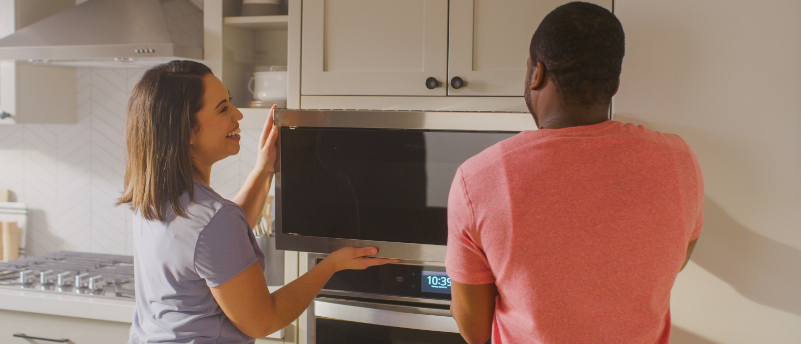 Man and woman installing a microwave