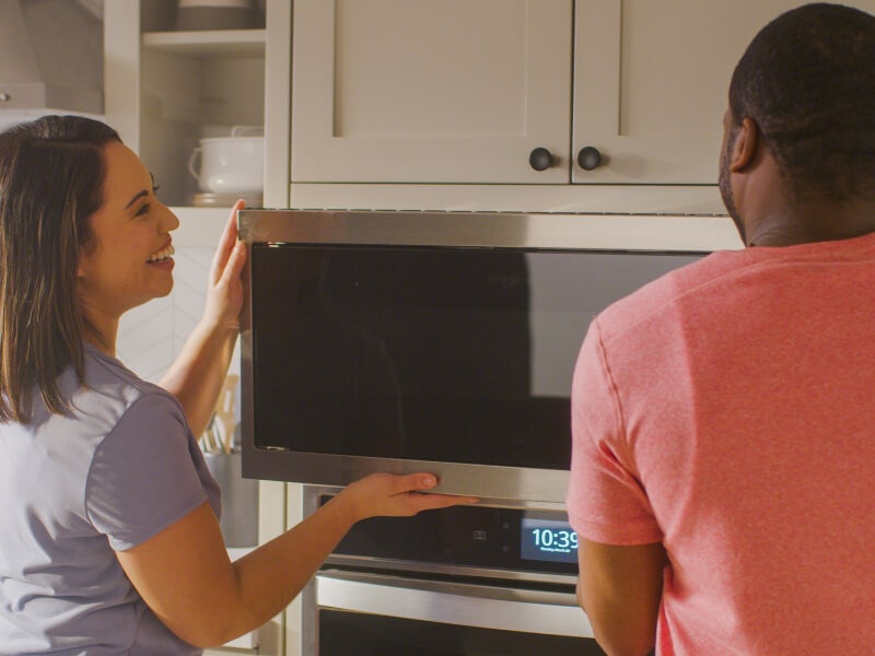 Man and woman installing a microwave