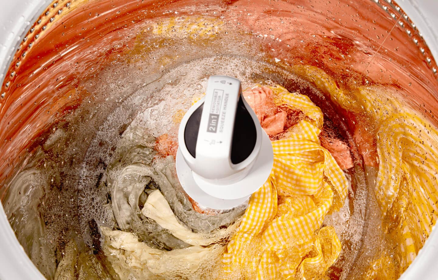 A Whirlpool® Top Load Washer with 2 in 1 Removable Agitator open with clothes inside A Whirlpool® Top Load Washer with 2 in 1 Removable Agitator open with clothes inside