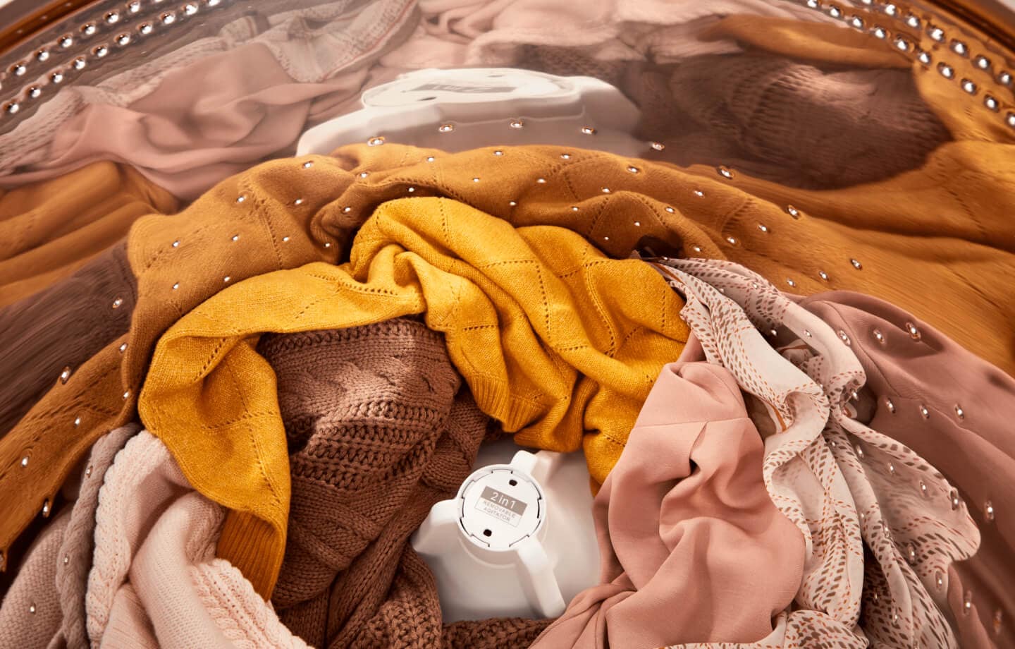 A Whirlpool® Top Load Washer open with clothes inside A Whirlpool® Top Load Washer open with clothes inside