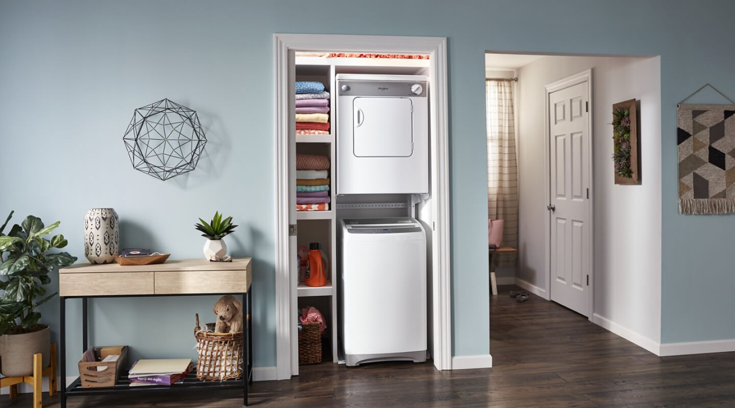 White stacked washer and dryer in a closet