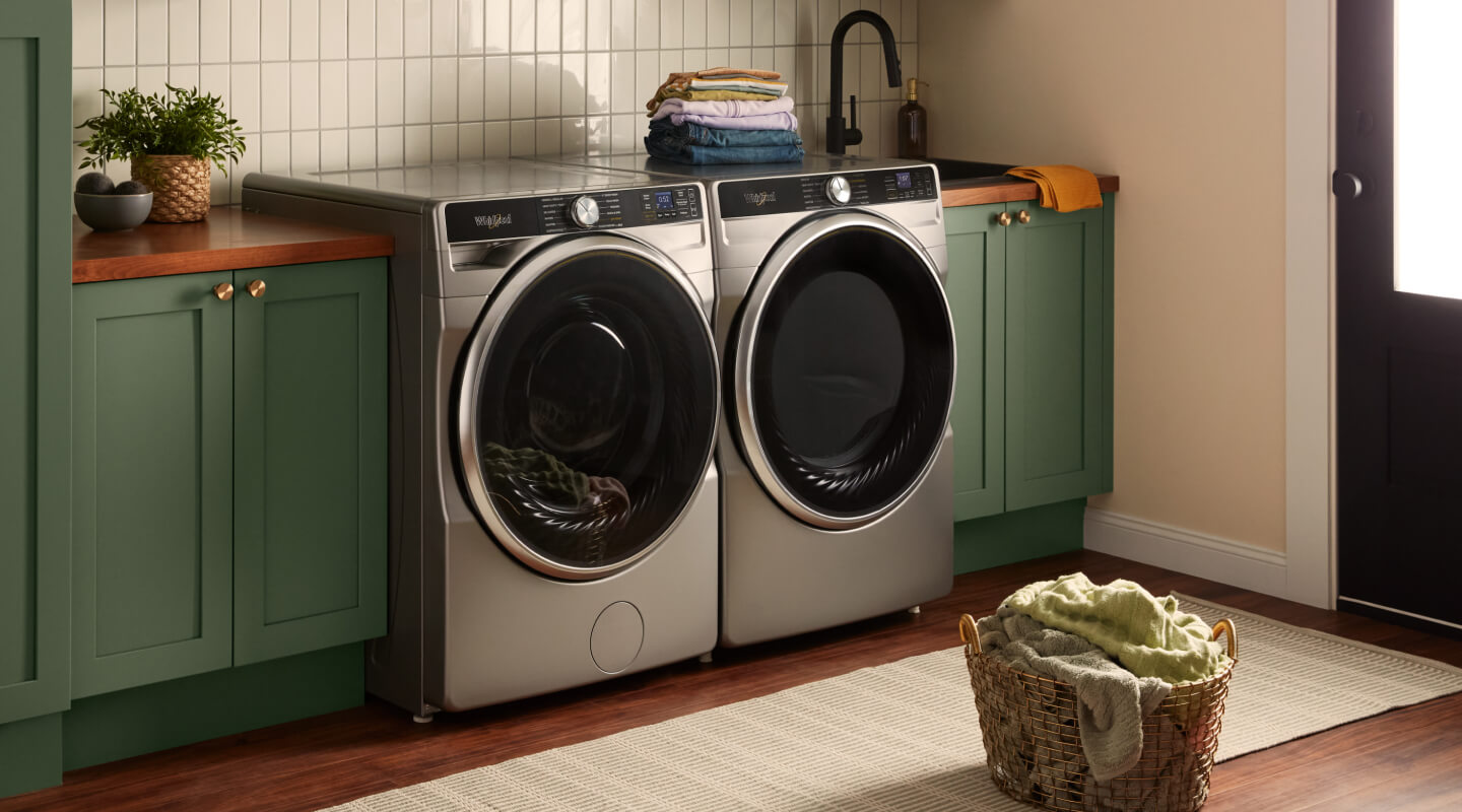 Front load washer and dryer set in a green and white laundry room