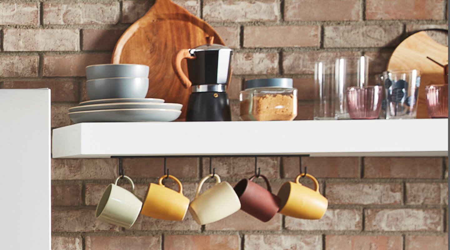White shelves filled with mugs and coffee accessories White shelves filled with mugs and coffee accessories