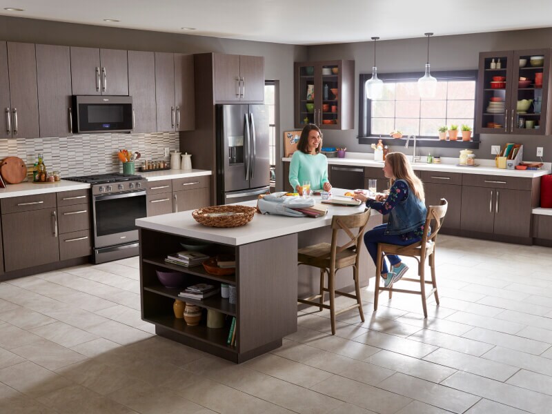 Two women sitting around a kitchen island Two women sitting around a kitchen island