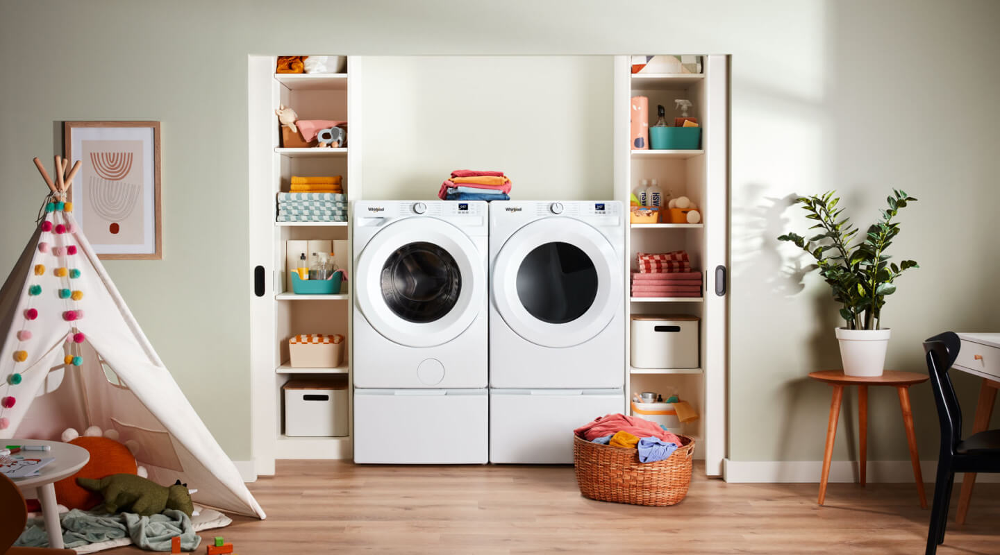 A white Whirlpool® Washer and Dryer set in a laundry area surrounded by shelving