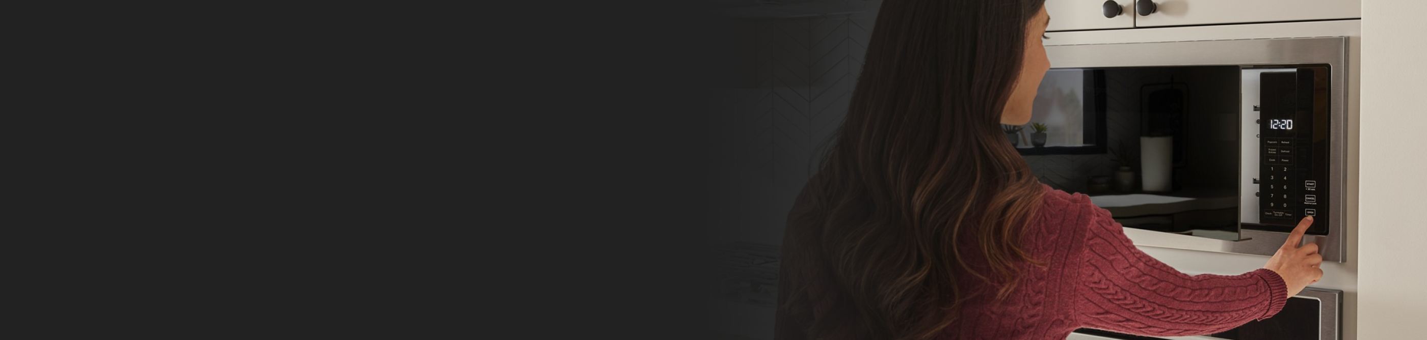 A profile view of a person using a microwave.