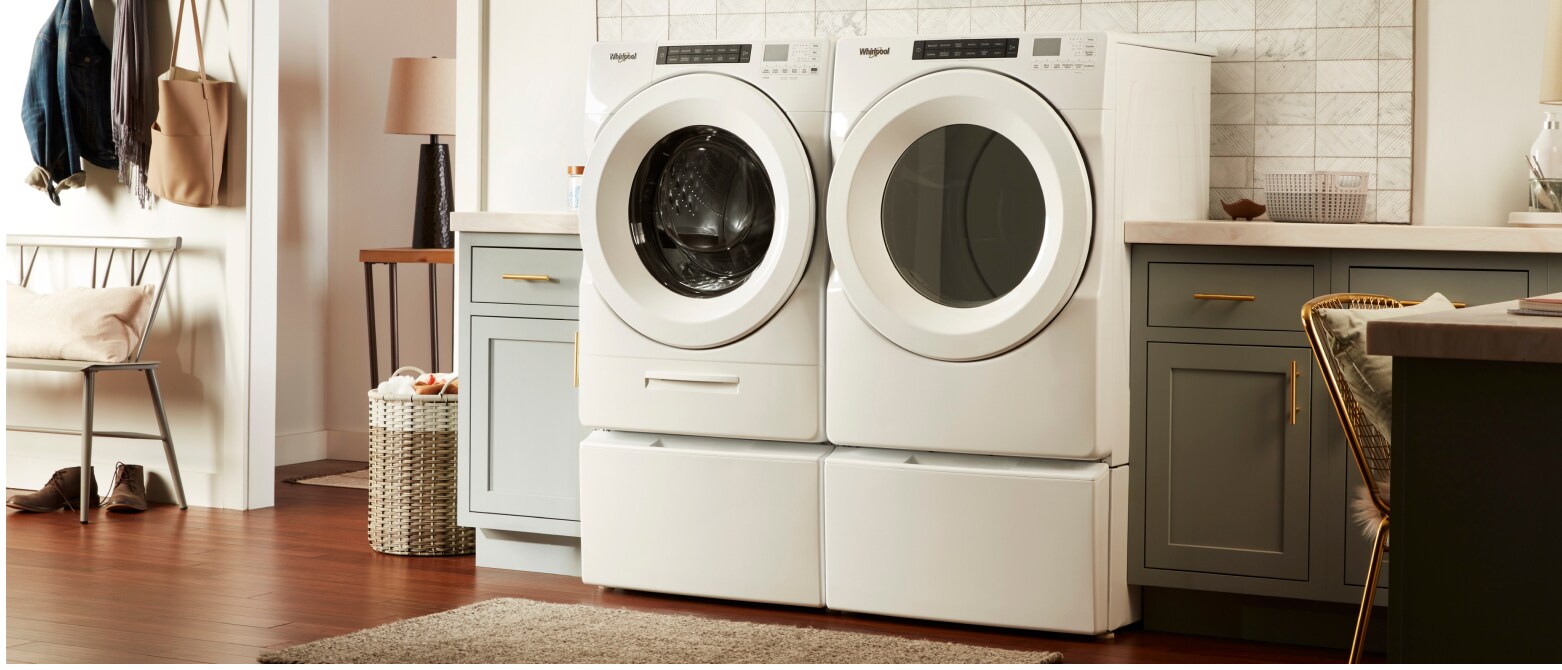 A Whirlpool® Front Load Washer and Dryer pair in white with laundry pedestals