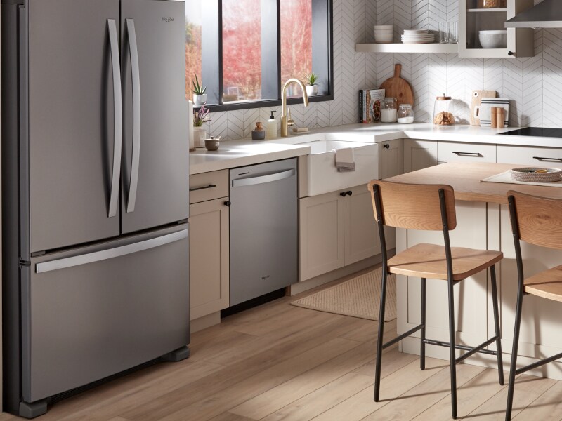 A Whirlpool® dishwasher and appliances in a kitchen with an island. A Whirlpool® dishwasher and appliances in a kitchen with an island.