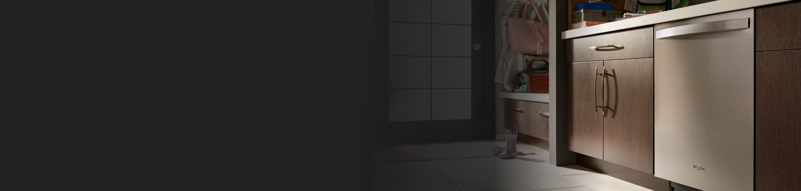 A Whirlpool® Top Control Dishwasher surrounded by brown cabinetry.