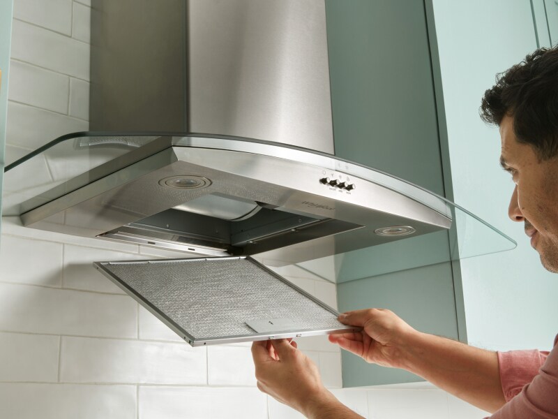 Person removing range hood filter Person removing range hood filter