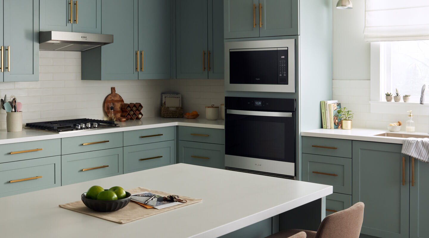 Kitchen with blue-green cabinets and Whirlpool® appliances