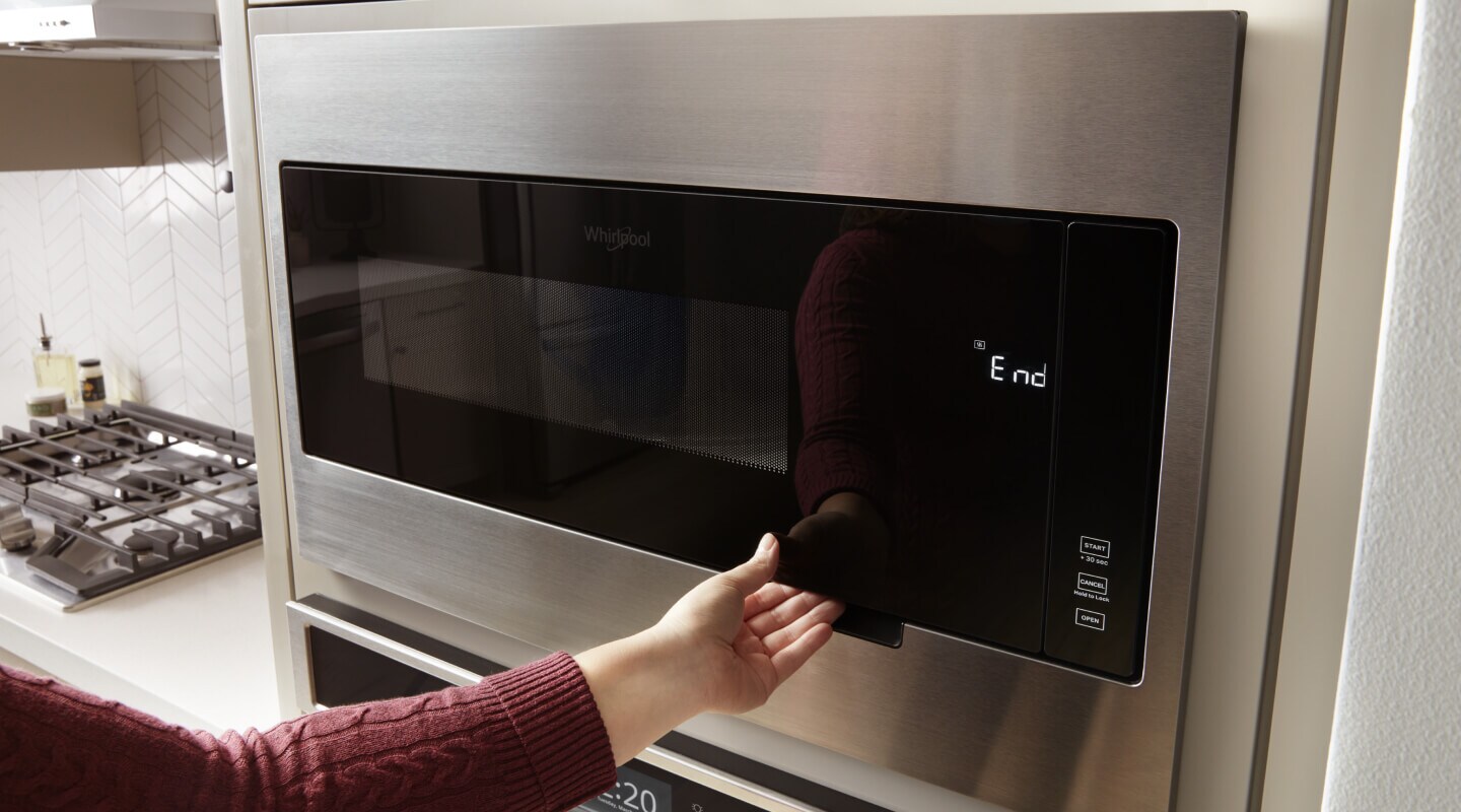 Hand opening a microwave door Hand opening a microwave door