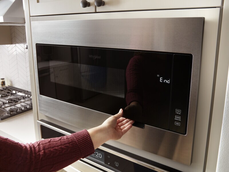 Hand opening a microwave door Hand opening a microwave door