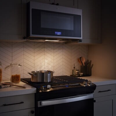 A microwave light illuminating the top of a stove