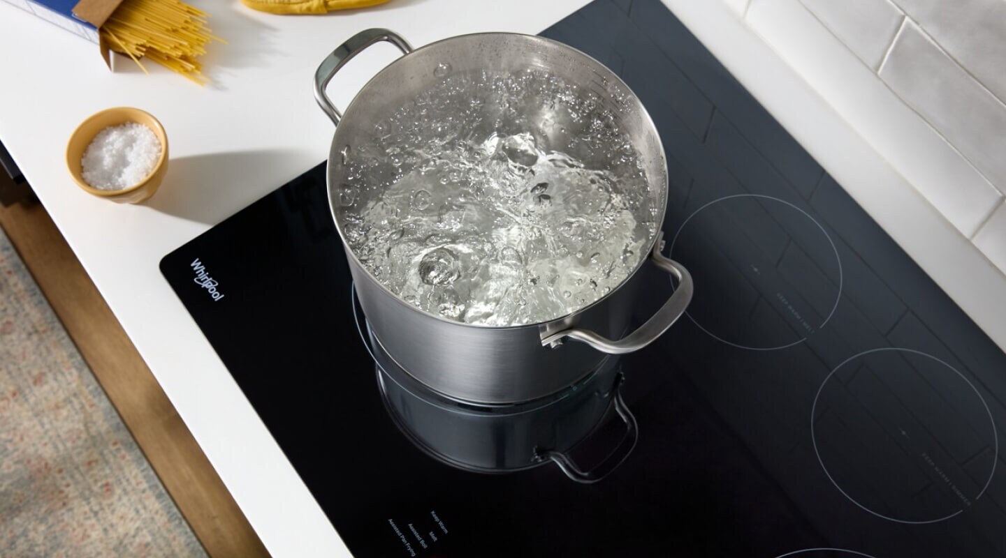 A pot of water boiling on a Whirlpool® Cooktop