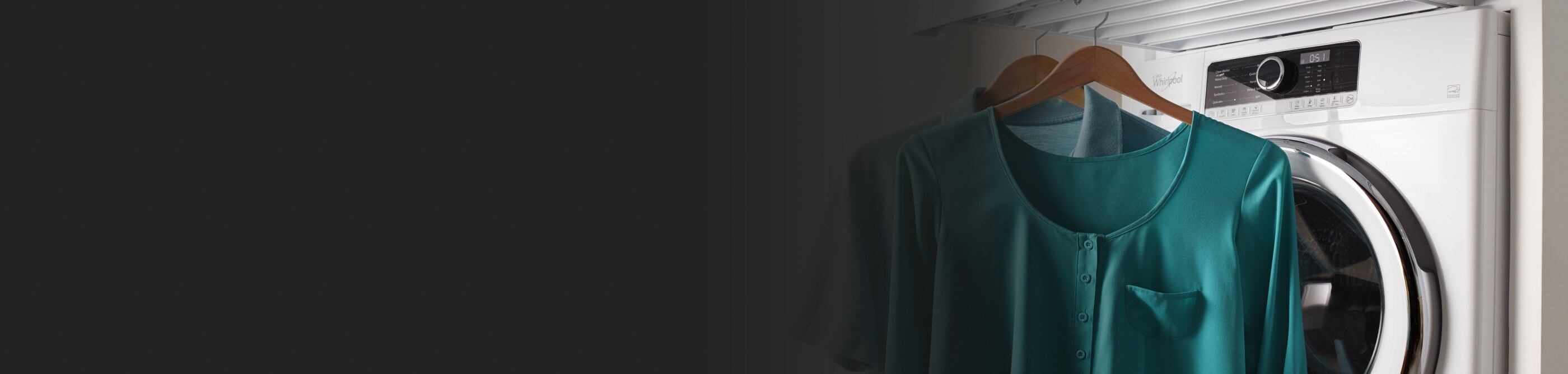 Two freshly dried shirts hanging in front of a Whirlpool® washing machine