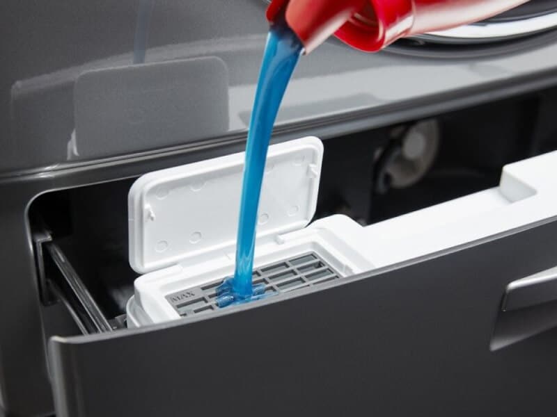 Blue HE detergent flowing into a dispenser