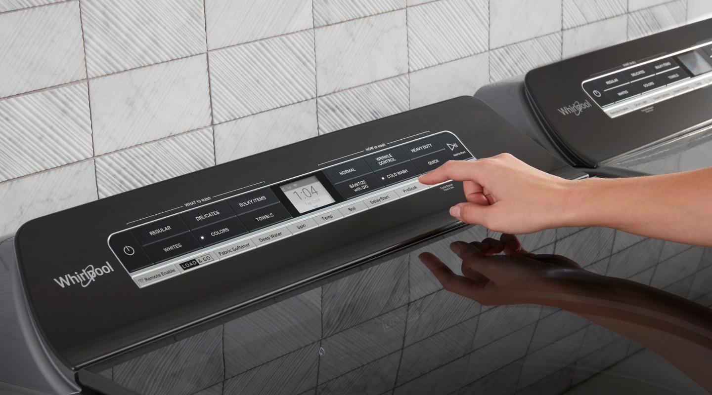 A person selects a laundry cycle from a touchpad A person selects a laundry cycle from a touchpad