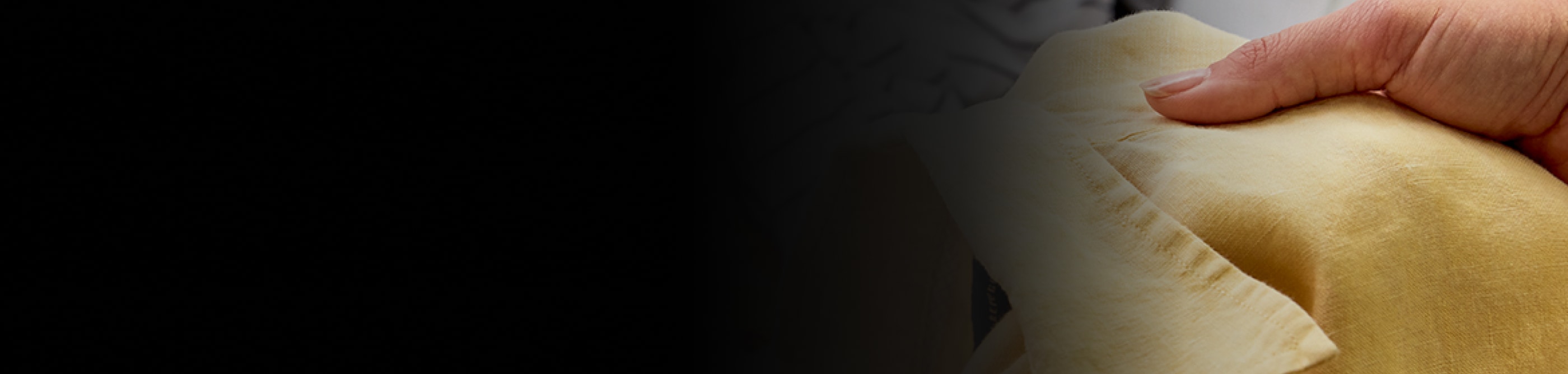 A person holds up a t-shirt that just came out of a Permanent Press cycle