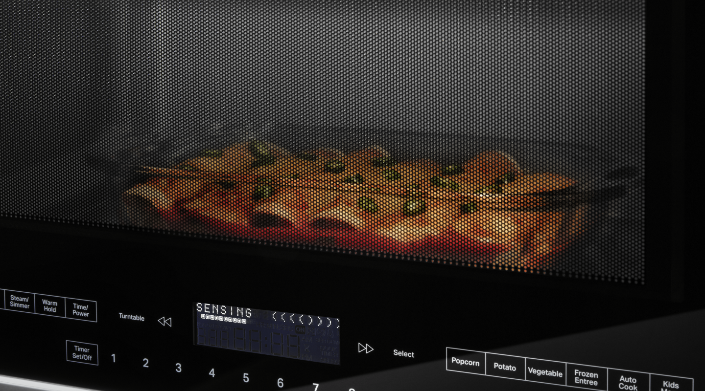 A closeup of enchiladas cooking in a Whirlpool® microwave. A closeup of enchiladas cooking in a Whirlpool® microwave.