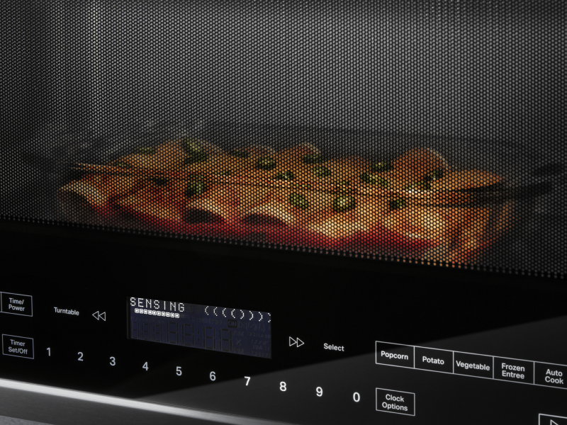 A closeup of enchiladas cooking in a Whirlpool® microwave. A closeup of enchiladas cooking in a Whirlpool® microwave.