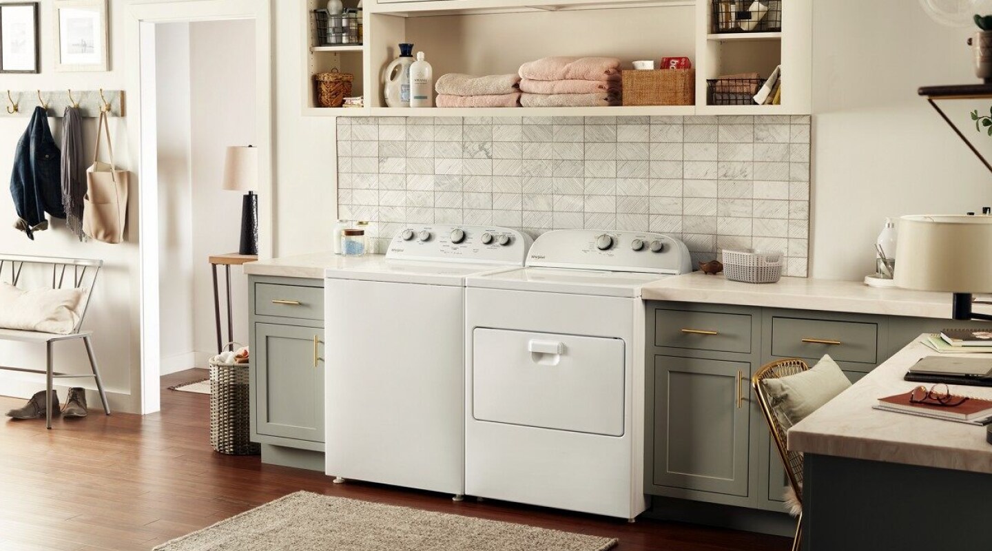 White Whirlpool® Top Load Washer and Dryer pair in a large laundry room