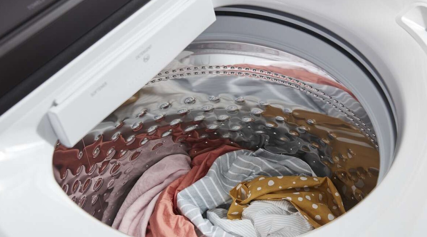 Close-up of a top load washer drum filled with clothes