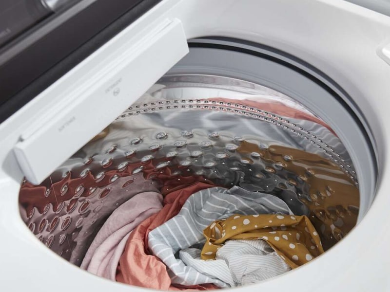 Close-up of a top load washer drum filled with clothes