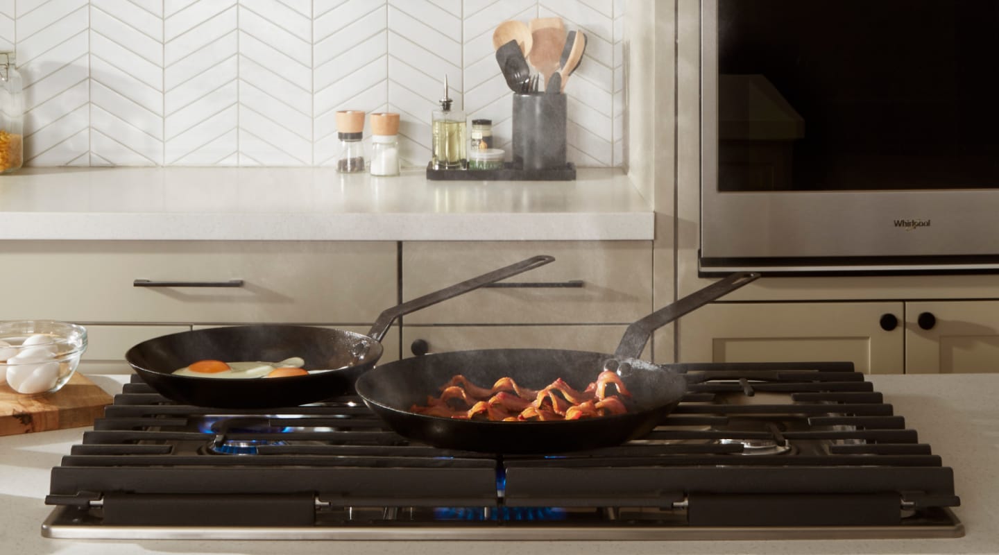 Pans cooking food on a Whirlpool® cooktop Pans cooking food on a Whirlpool® cooktop