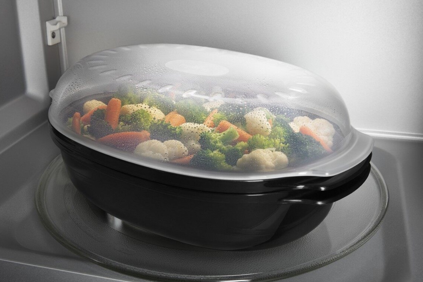 A tray of vegetables inside a microwave. A tray of vegetables inside a microwave.