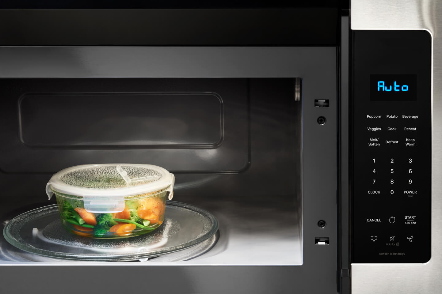 Vegetables in a microwave safe container inside the cavity of a microwave