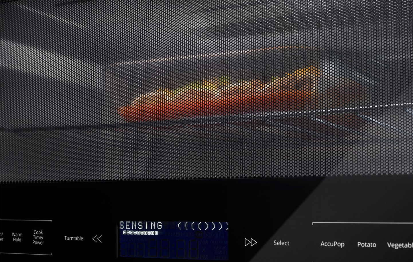 A casserole dish heating in a microwave. A casserole dish heating in a microwave.