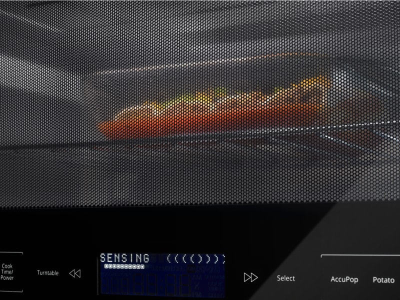 A casserole dish heating in a microwave. A casserole dish heating in a microwave.