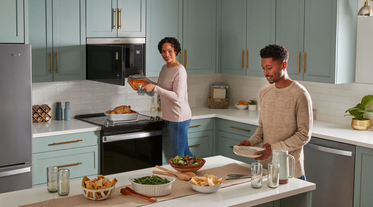 A person using a microwave in a kitchen