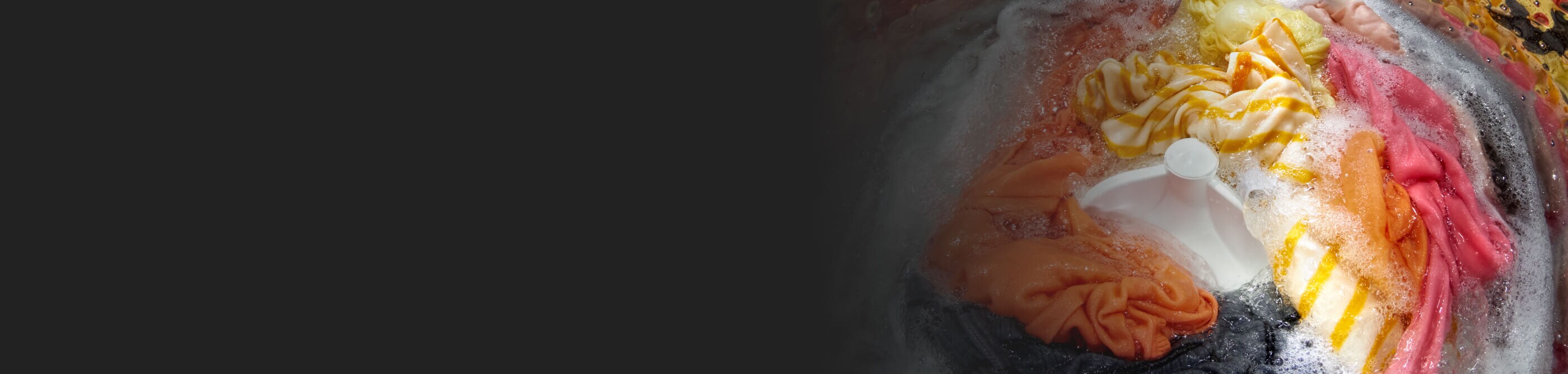 A load of colored clothes in a washing machine with an impeller