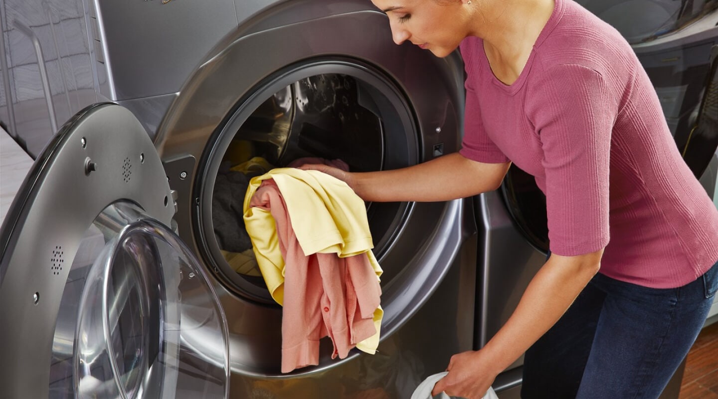 Person removing clothes from a dryer Person removing clothes from a dryer