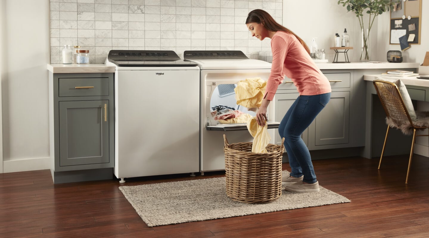 Person unloading clothes from a Whirlpool® Dryer