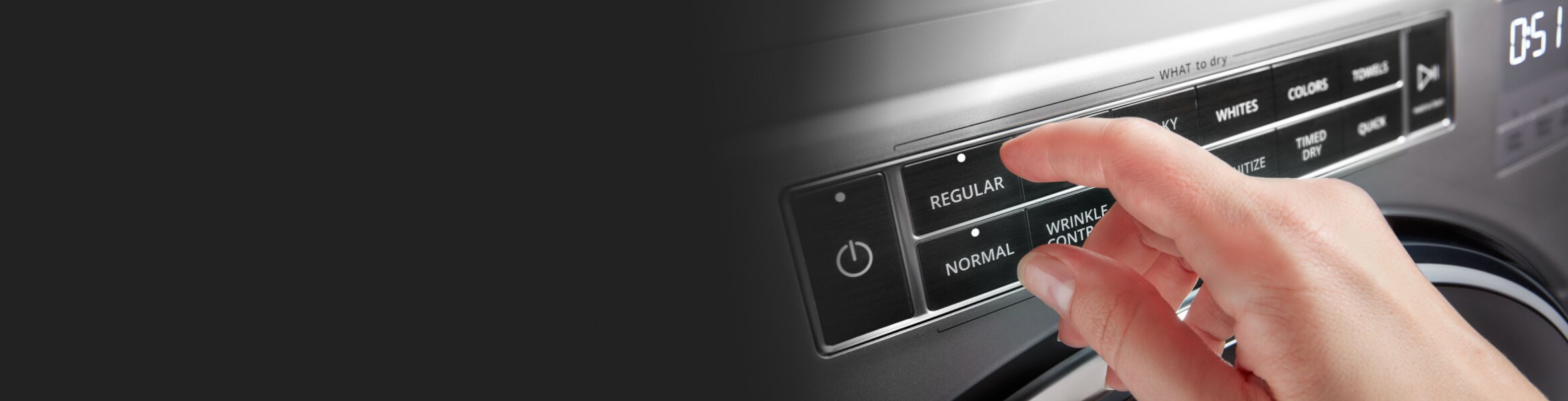 A person adjusting controls on a stainless steel dryer