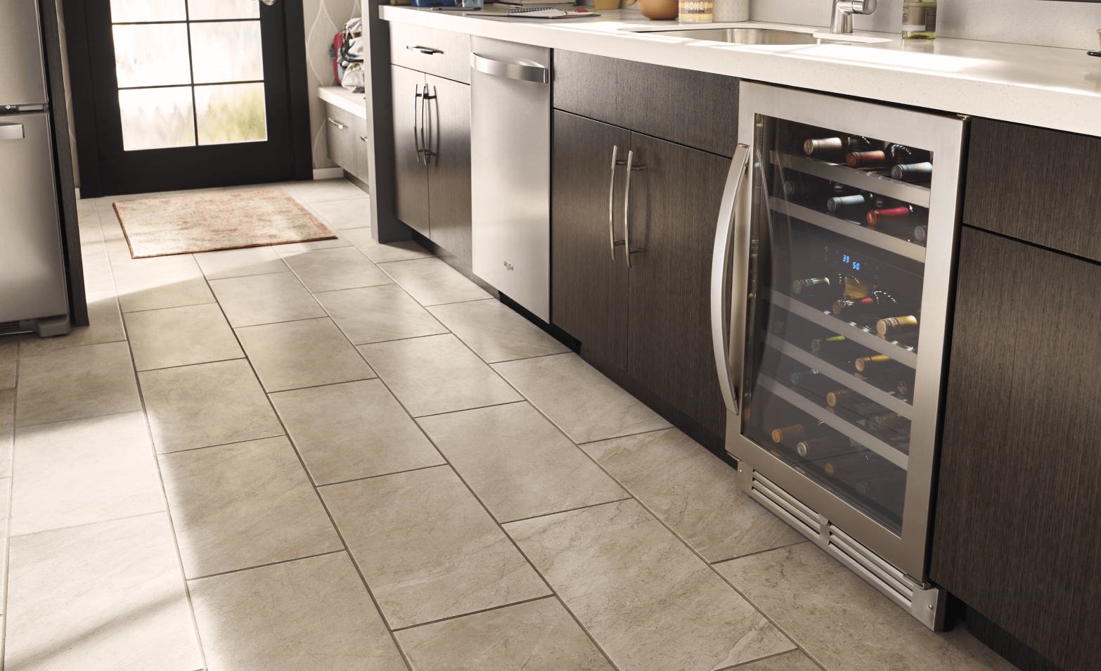 Stocked, under-counter wine refrigerator in kitchen surrounded by brown cabinetry