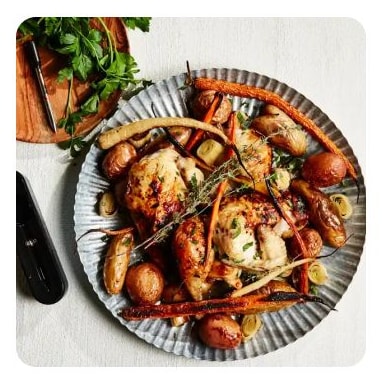 A plate of roasted chicken, potatoes and carrots with herbs A plate of roasted chicken, potatoes and carrots with herbs