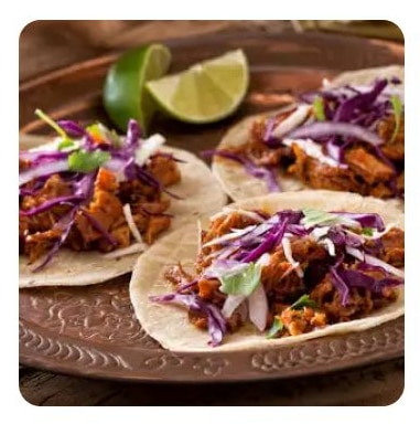 Three pork tacos with purple cabbage and lime Three pork tacos with purple cabbage and lime
