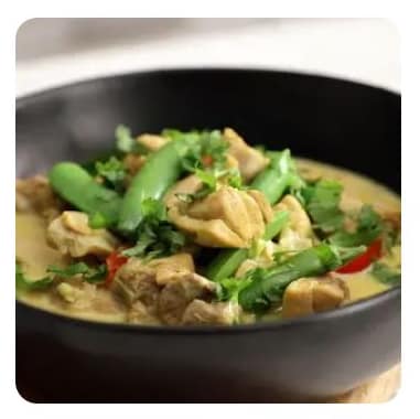 A shallow bowl of green chicken curry