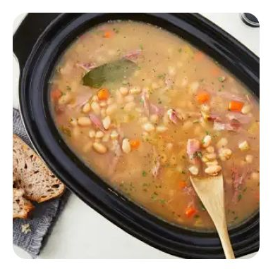 A slow cooker filled with ham and bean soup