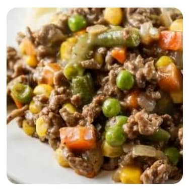 Close up of ground beef mixed with peas, carrots and corn