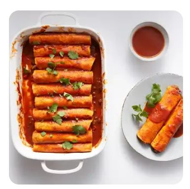 A white baking dish filled with enchiladas A white baking dish filled with enchiladas