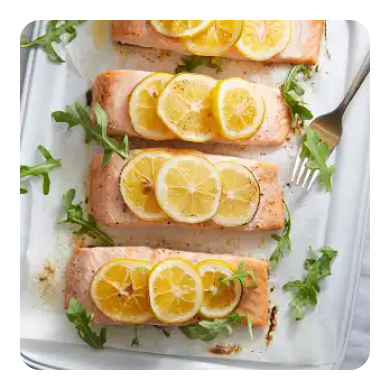 A platter of salmon filets with sliced lemons and arugula A platter of salmon filets with sliced lemons and arugula