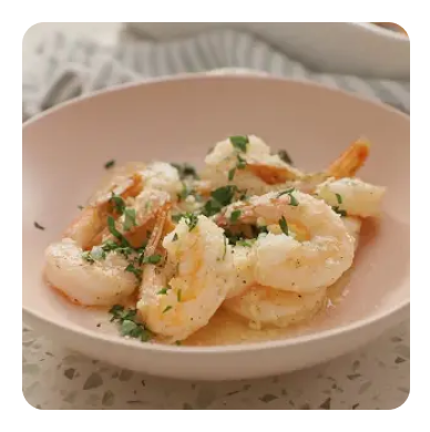 Shrimp with herbs in a light pink dish