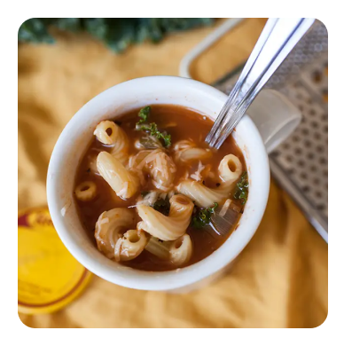 A small bowl of minestrone soup with noodles
